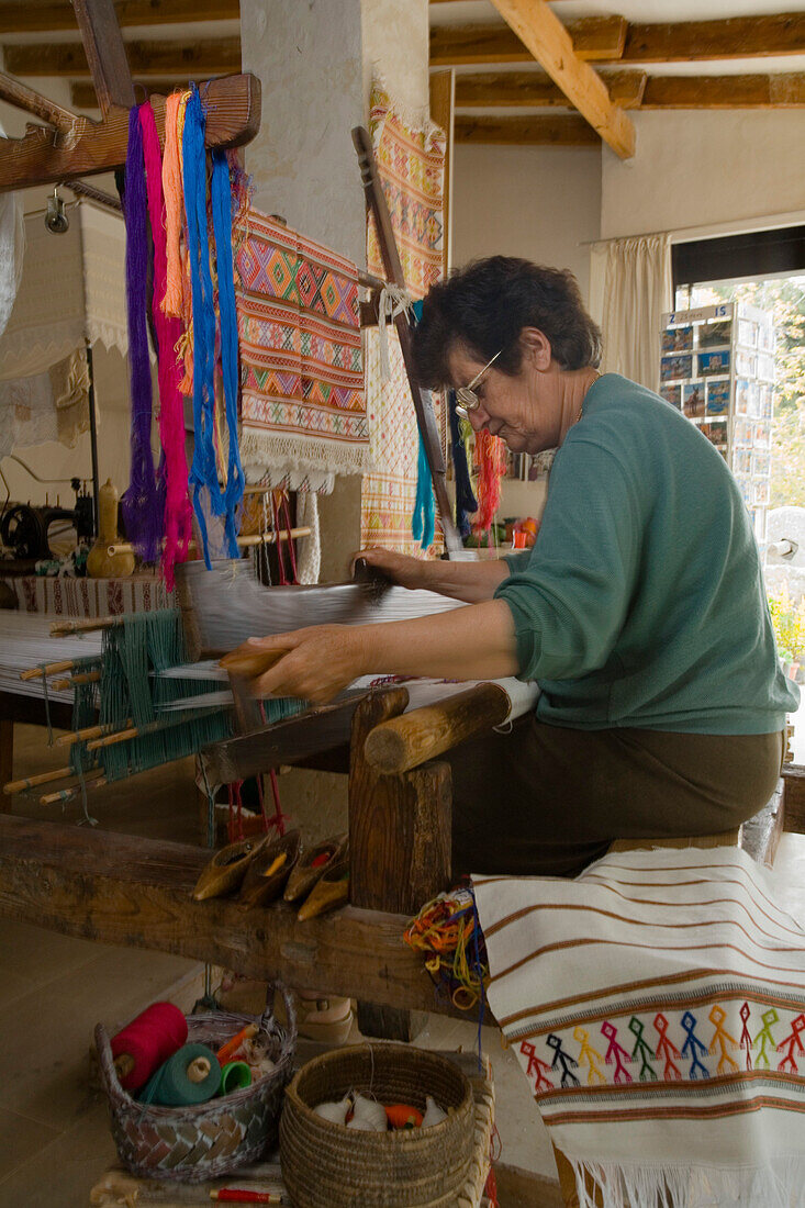 Woman weaving at a weaving loom in a local history museum, Fythi, Troodos mountains, South Cyprus, Cyprus