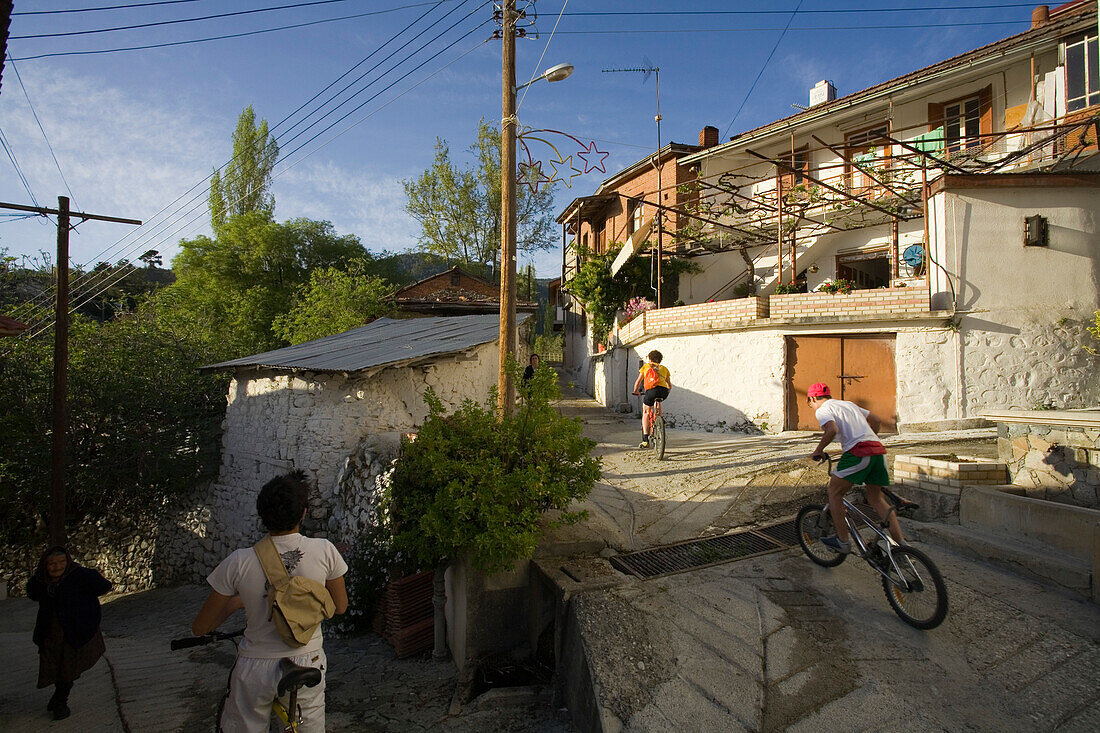 Leute fahren mit dem Fahrrad durch Lemithou, Troodos Gebirge, Südzypern, Zypern