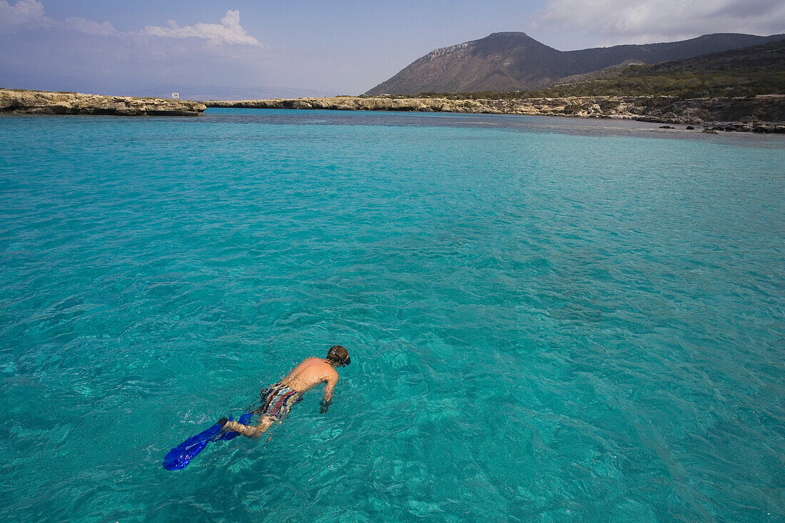 Man snorkeling in the sea during trip in a glass bottom boat with Spyros Plakides, Akamas coast, from Latsi harbour, near Polis, Cyprus