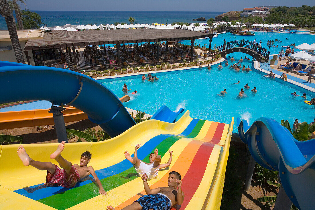 Three young men on a water slide, water park, Acapulco Beach Club and Resort Hotel, 10km east of Kyrenia, Girne, Keryneia, Cyprus