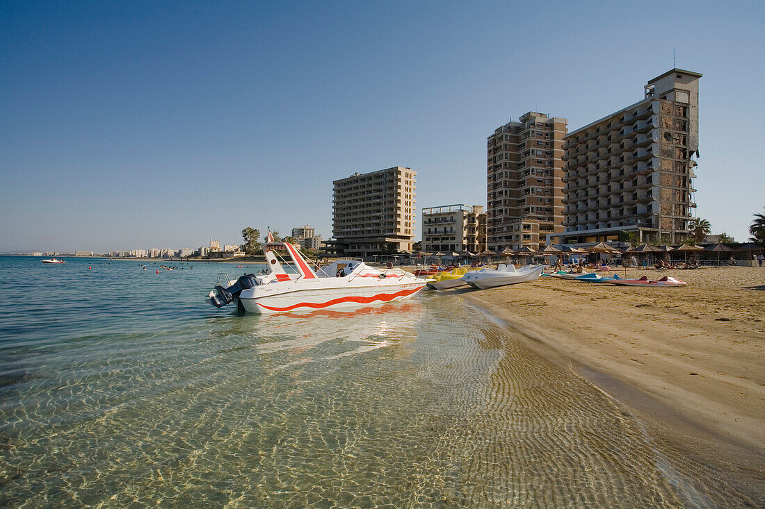 Boote am Strand, Varosha Strand mit Ruinen von Hotelanlagen im Hintergrund, Hotelruinen, Geisterstadt Varosha, Famagusta, Ammochostos, Gazimagusa, Nordzypern, Zypern