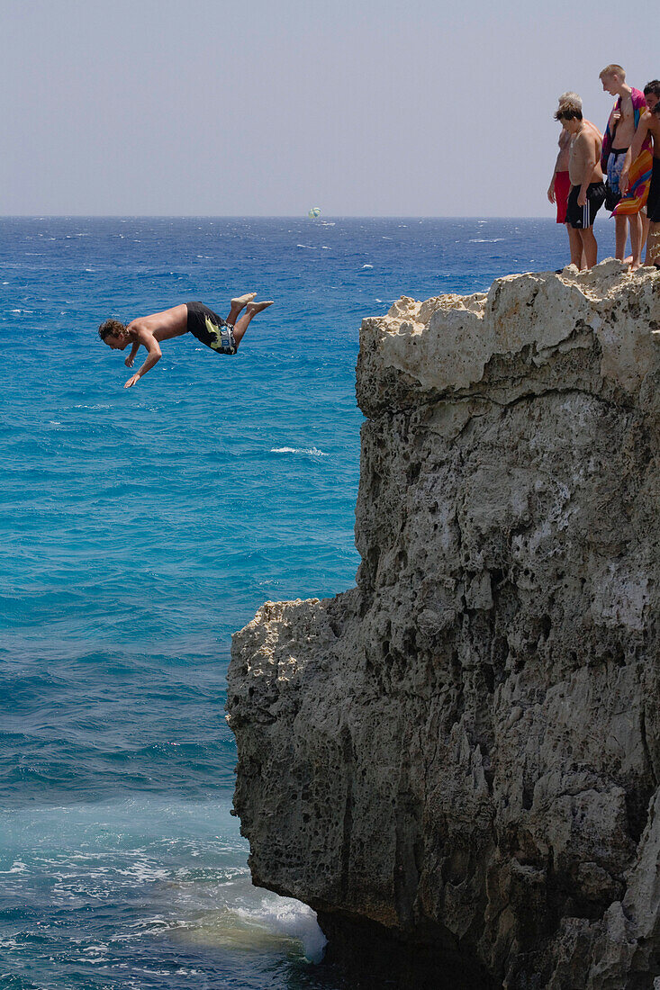 Man cliff jumping, diving from a the rock, Nissi island, Nissi beach, Agia Napa, South Cyprus, Cyprus