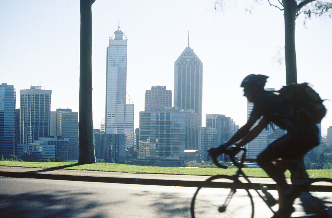 Man biking in Perth with skyline at background. Australia