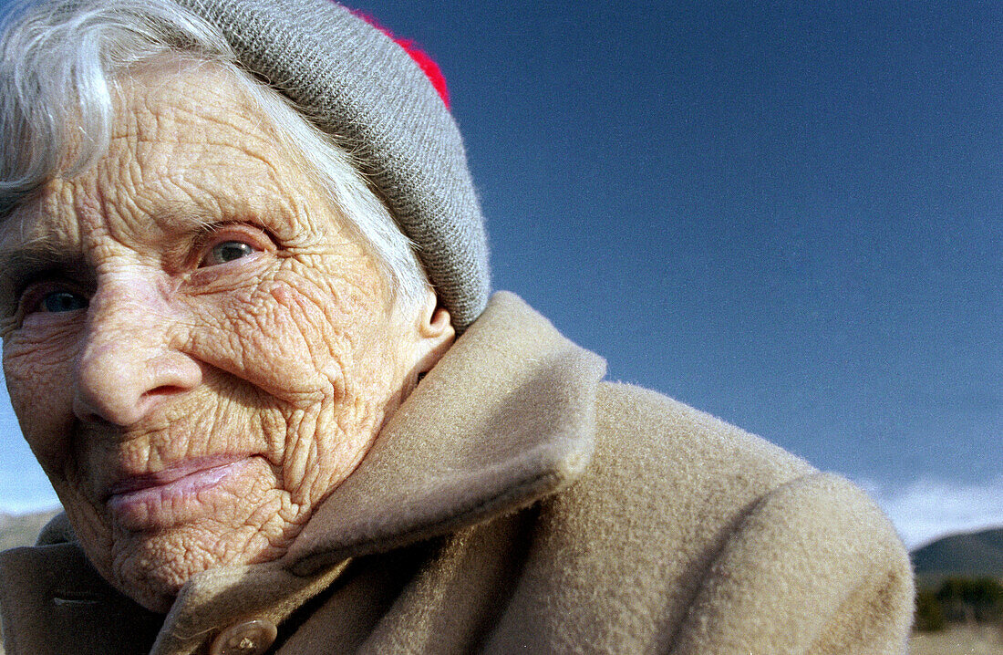 Cold, Color, Colour, Contemporary, Daytime, Elderly, Exterior, Face, Faces, Female, Gray-haired, Grey-haired, Headgear, Horizontal, Human, Looking at camera, Mature adult, Mature adults, Mature people
