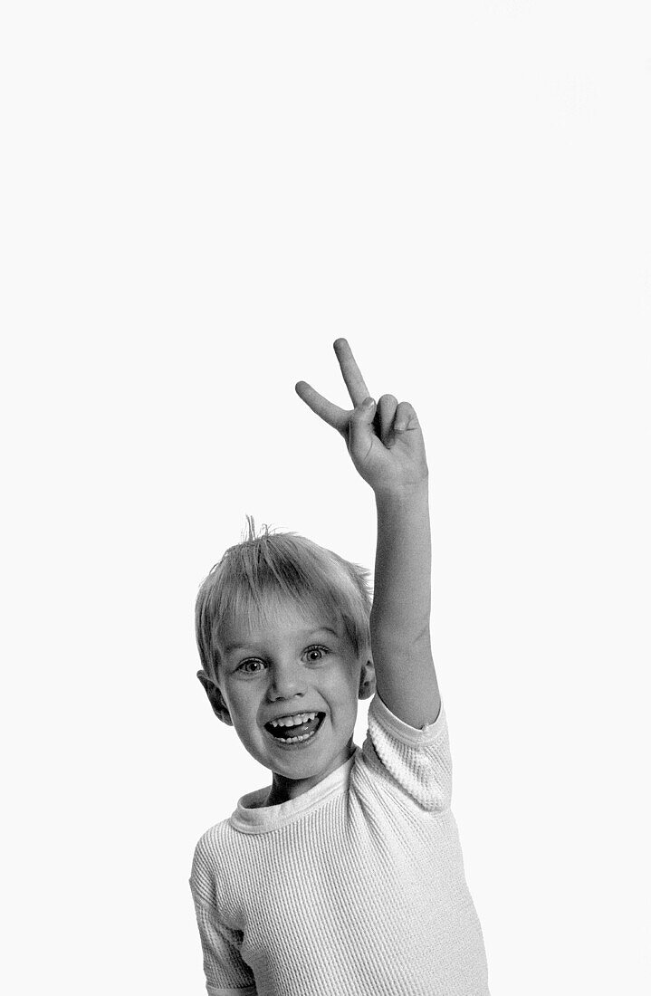 image of young boy making a peace sign with his fingers