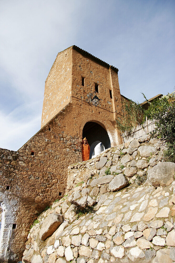 North African man. Tower and gate. Chefchaouen. Morocco