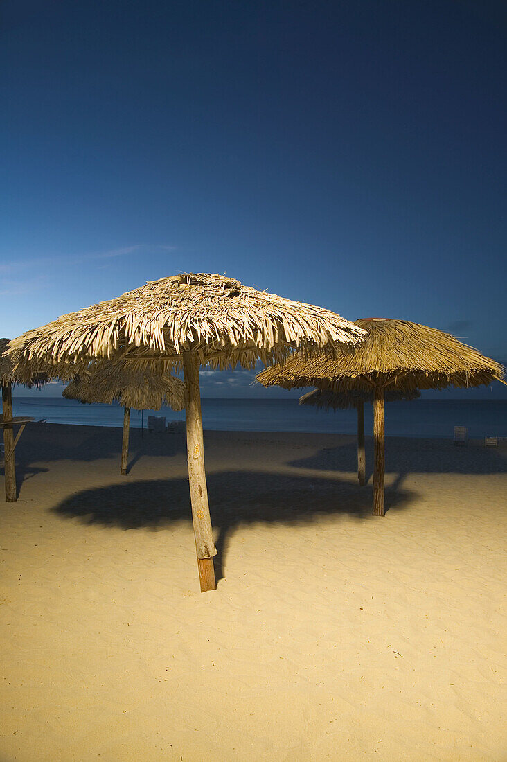 An evening view of a beach and shade providers in Varadero, Cuba.