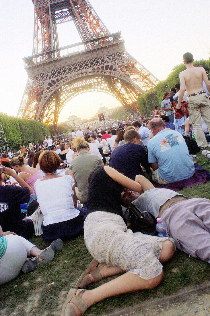 Couple kissing on grass near Eiffel tower. Paris. France