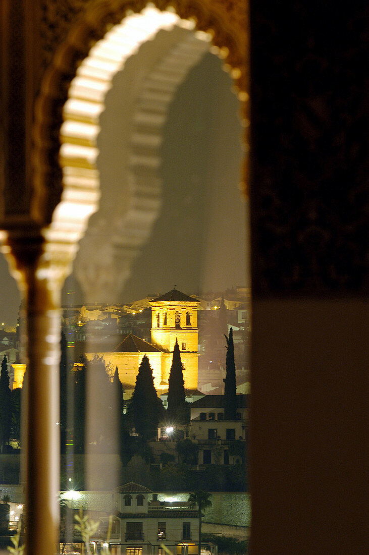 Night view of San Jose Church through a sculpted window of the Alhambra. Granada. Andalucia. Spain