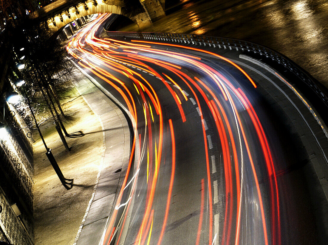 Stream of car headlights along the banks of the Seine at night. Paris. France