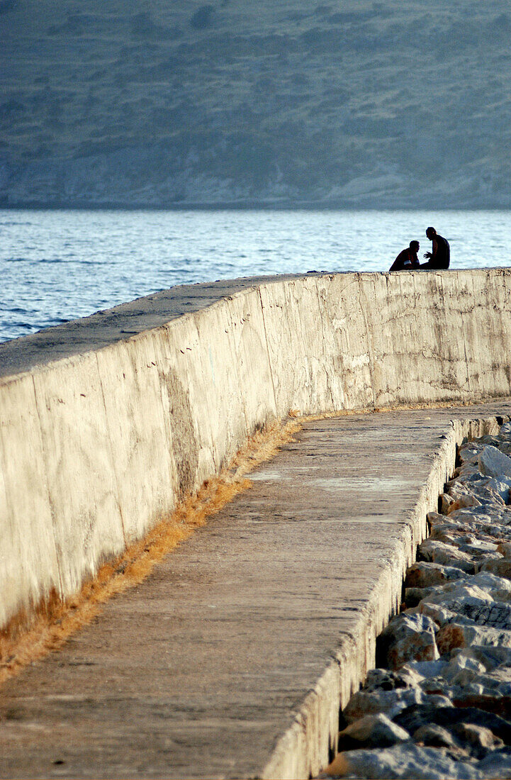 Couple on wall next to port. Bodrum. Turkey