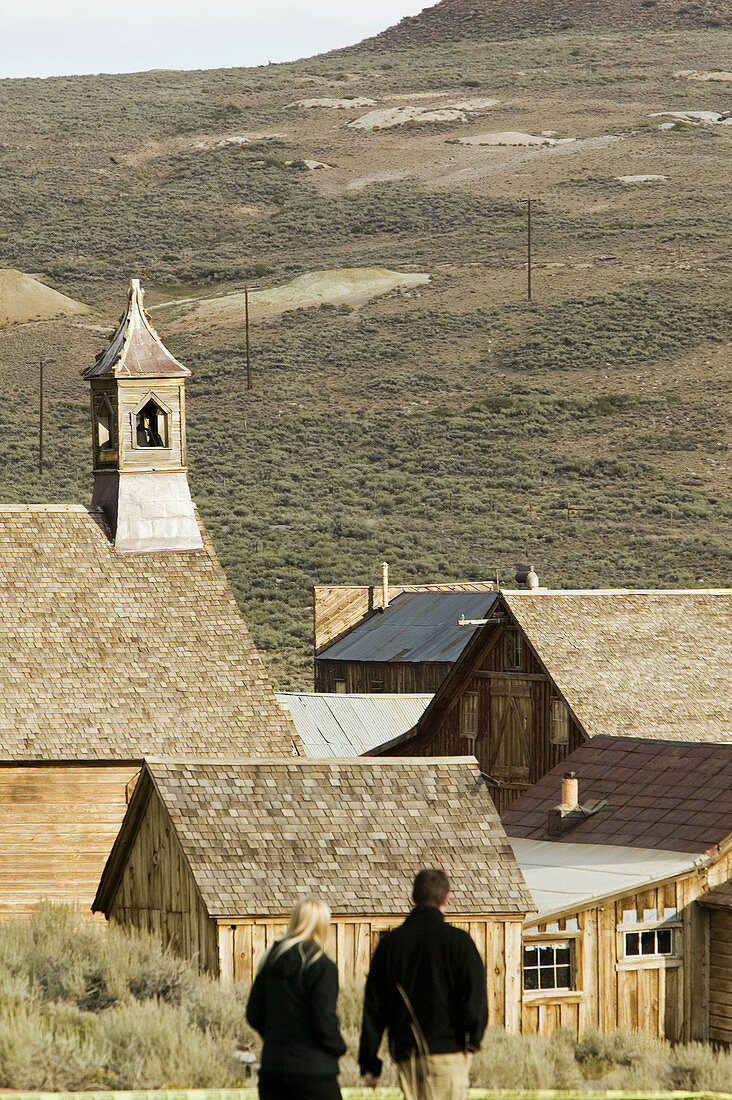 Tourists and old wooden buildings of the ghost town. Bodie State Historic Park. Bodie. California. United States