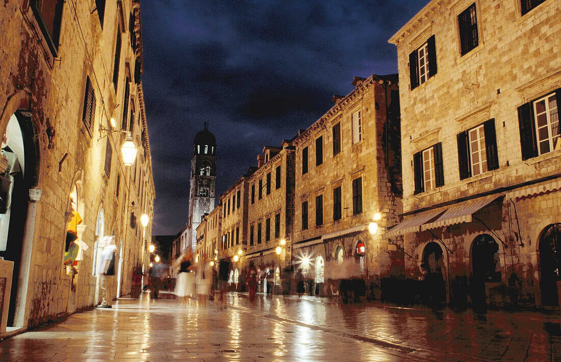 Looking West down the Stradun (square) towards pile gate and the Franciscan bell tower at night with shiny marble street surface, old town Dubrovnik. Croatia