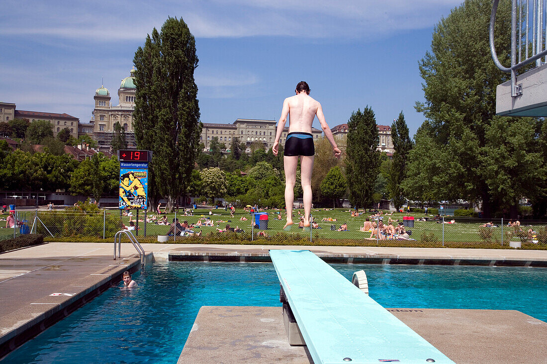 Mann springt vom Sprungbrett ins Wasser, Marzili Freibad, Aare, Bundeshaus, Bern, Schweiz