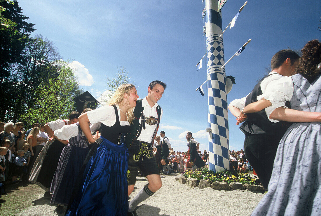 Junge Männer und Frauen tanzen um den Maibaum, Maibaumfest in Holzhausen, Feste in Bayern, Bayern, Deutschland