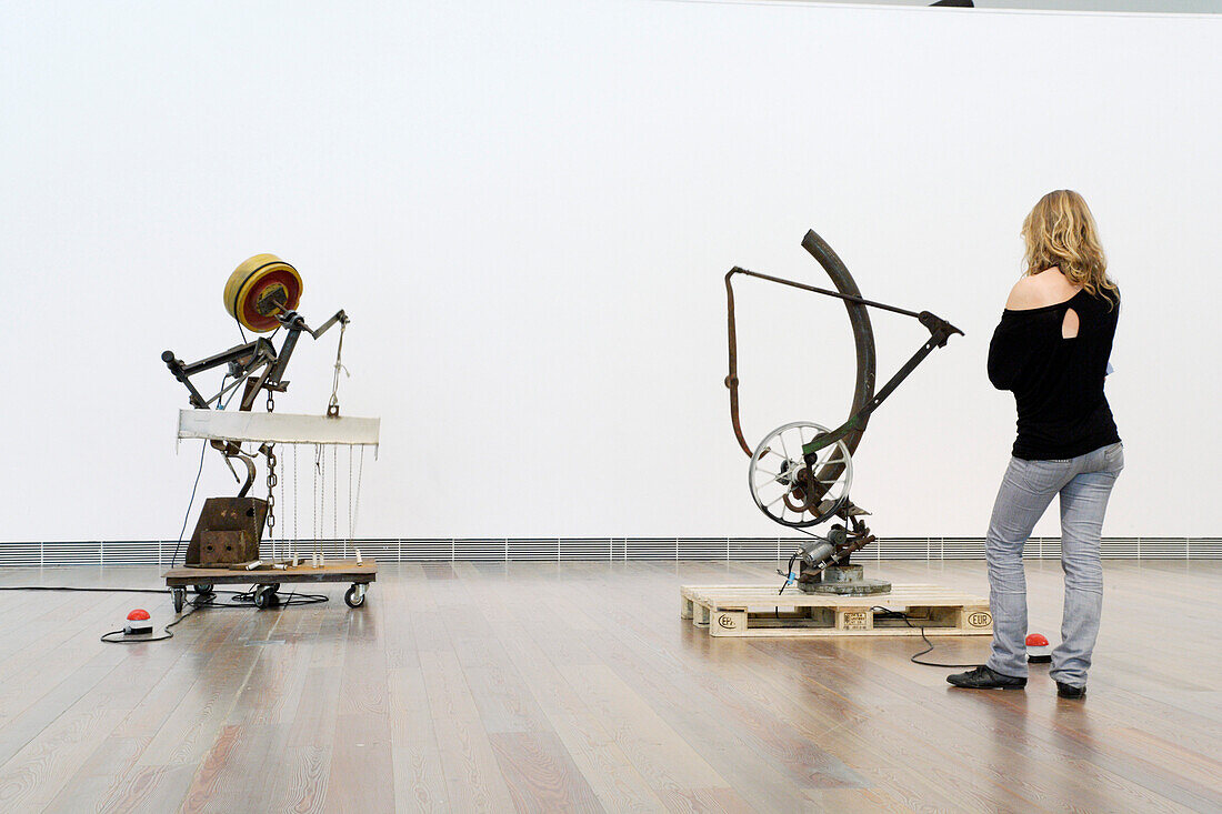 Eine junge Frau betrachtet die Skulpturen in Jean Tinguely Museum, Basel, Schweiz