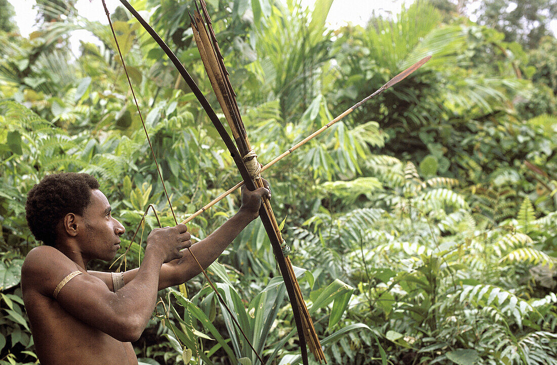 Stone Axe Korowai from the Din clan with bow and arrow. Lowlands near Beckham River. West Papua, Indonesia