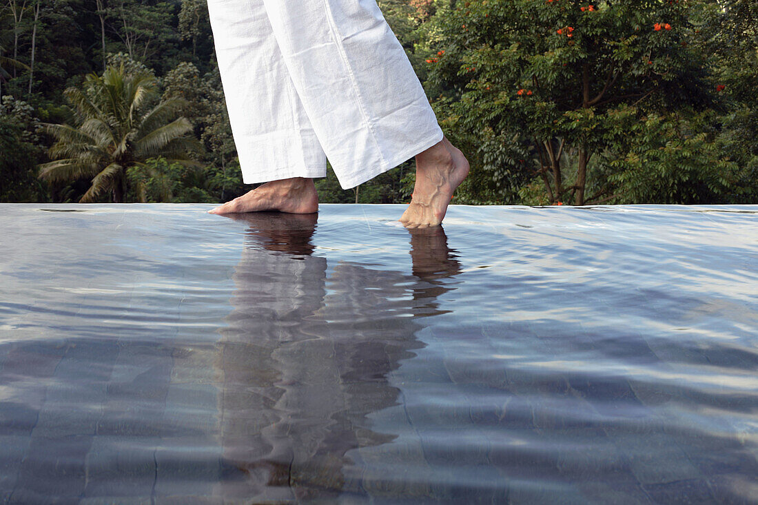 Man s feet on the edge of an outdoor pool at Losari Coffee Plantation in West Java, Indonesia, South East Asia