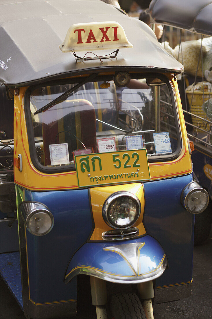 A Tuk Tuk - the famous three wheel taxi of Bangkok, notorious for its noise and pollution, waiting for customer at the roaside, Bangkok, Thailand, Southeast Asia