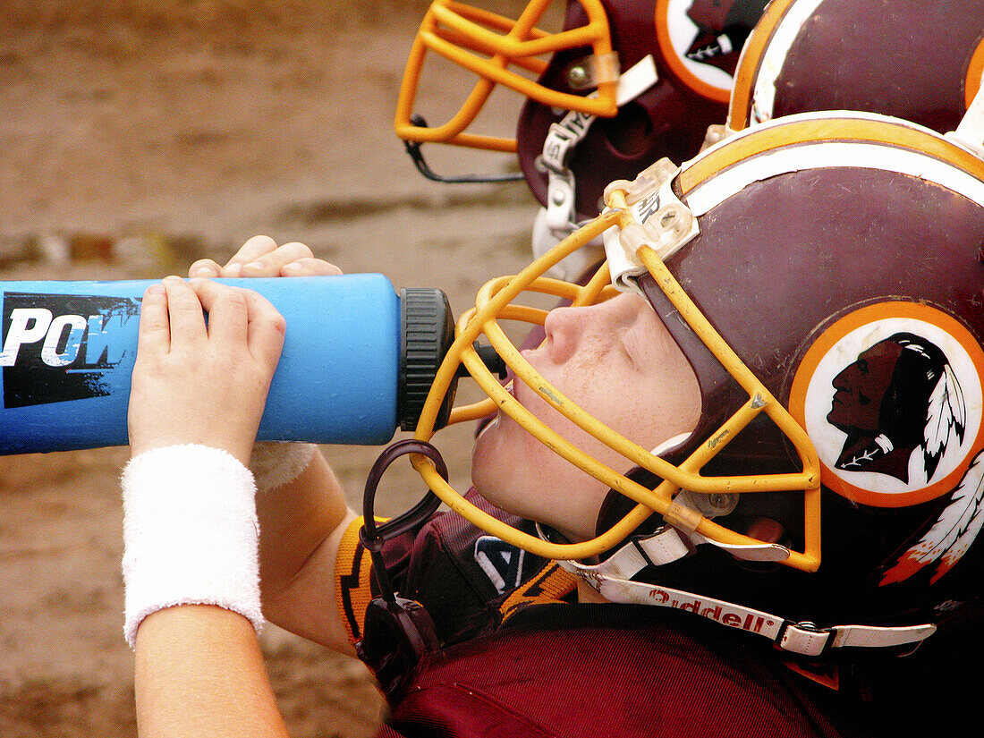 5 Year old boy drinking water at full contact football game