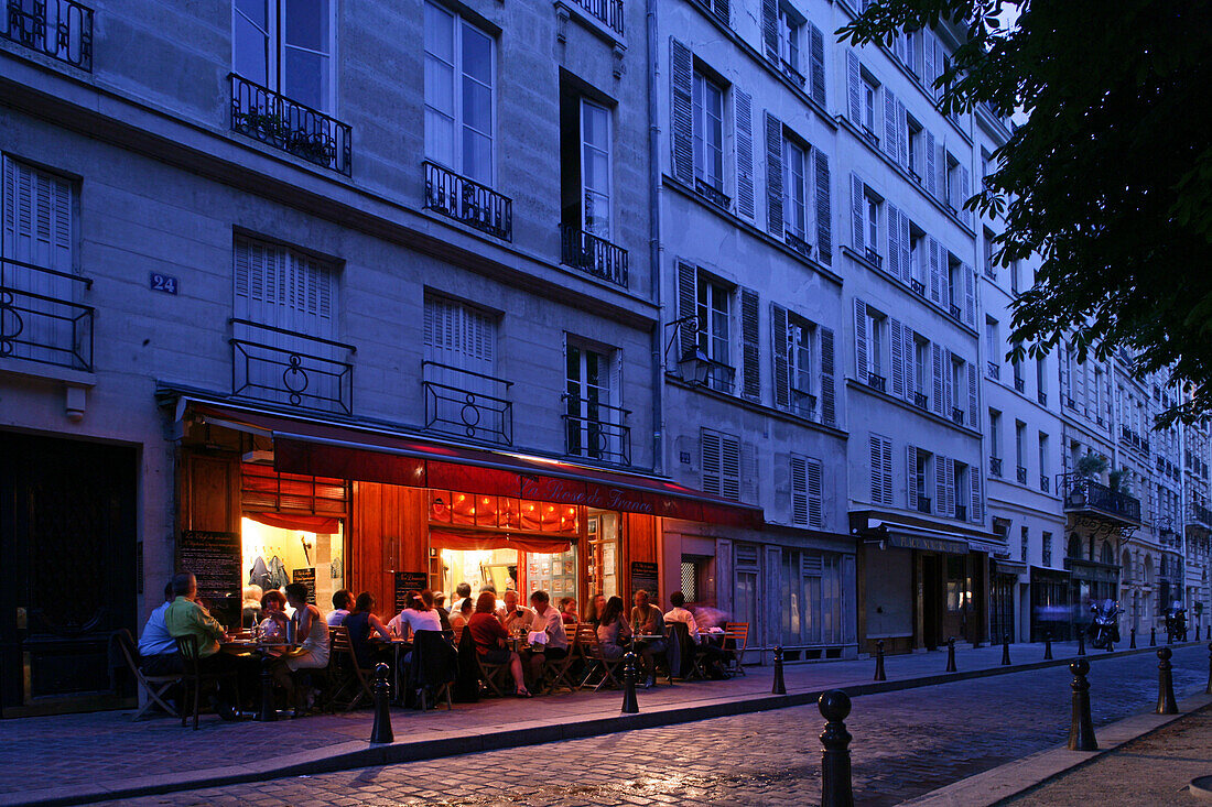 People sitting outside a Bistro in the evening light, Place Dauphine, Isle de la Cité, Paris, France