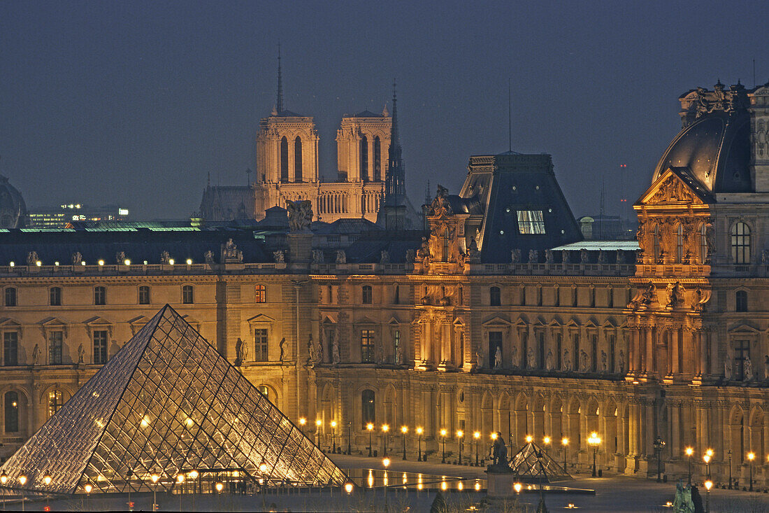 Louvre Museum with IM Pei Pyramide and Notre Dame in background, illumated at night, Paris, France