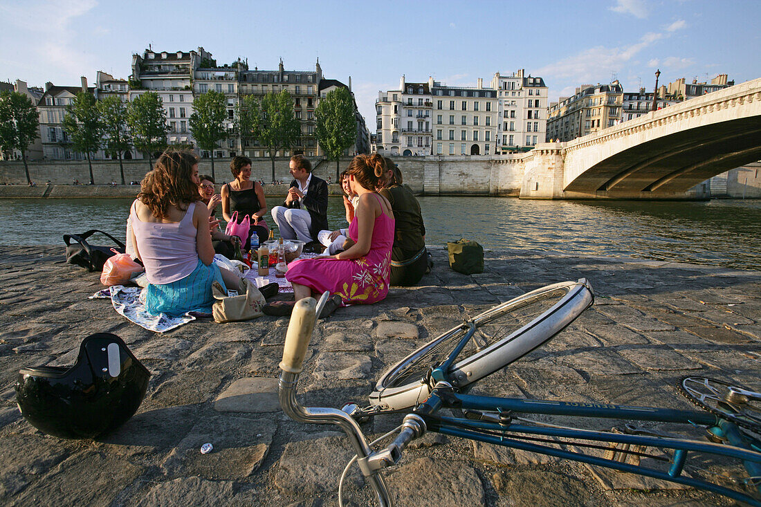 People relaxing on the banks of the river Seine, Paris, France, Europe