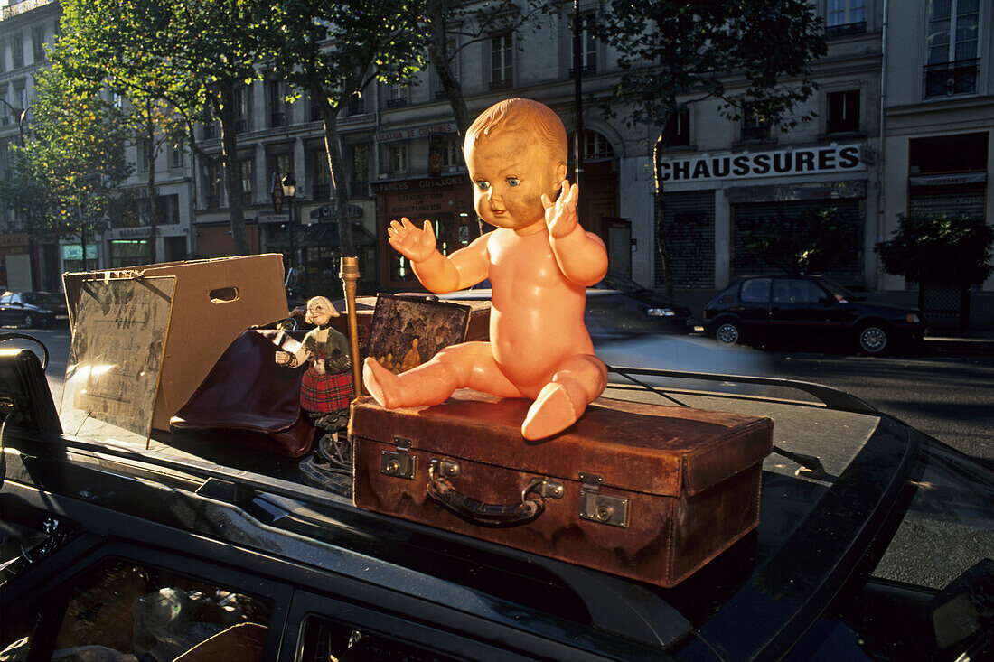 Naked doll and old suitcase at flea market, Paris, France, Europe