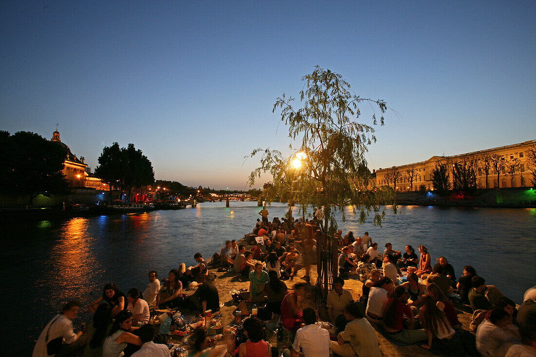 People relaxing on the tip of the Isle de la Cité in the evening, Paris, France, Europe