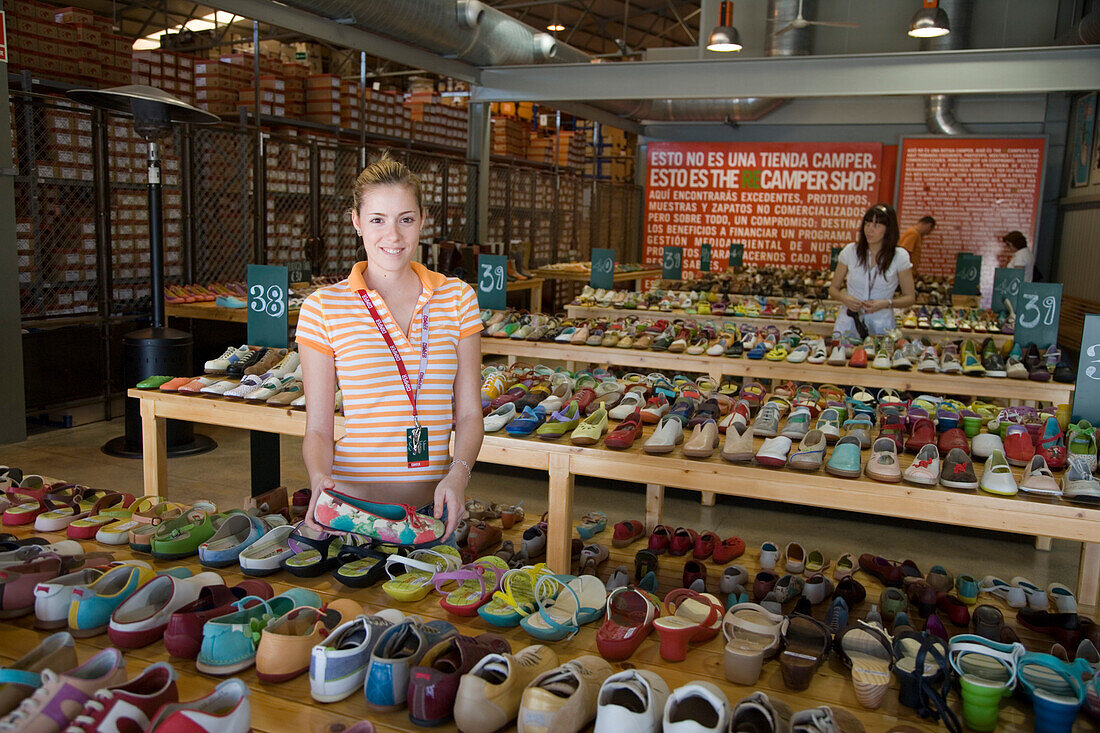 Junge Frau verkauft bunte Camper Schuhe im Camper Outlet Store, Inca, Mallorca, Balearen, Spanien, Europa