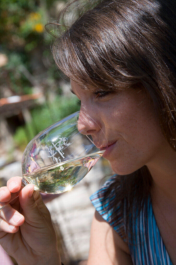 Junge Frau genießt Weißwein auf Terrasse des Xelini Restaurant, Deia, Mallorca, Balearen, Spanien, Europa