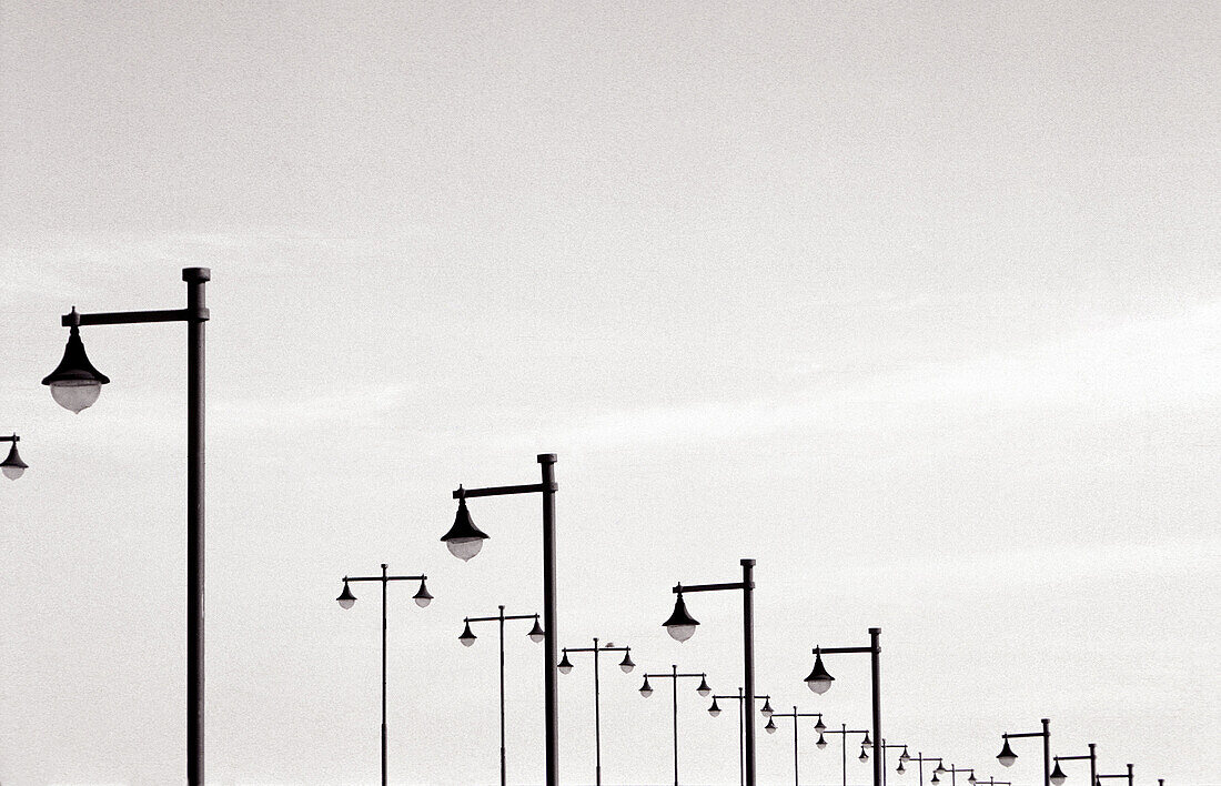 B&W, Black-and-White, Concept, Concepts, Daytime, Deserted, Exterior, Horizontal, Illumination, Lighting, Lined up, Lined-up, Many, Monochromatic, Monochrome, Outdoor, Outdoors, Outside, Perspective, Promenade, Promenades, Remote, Silence, Street lamp, St