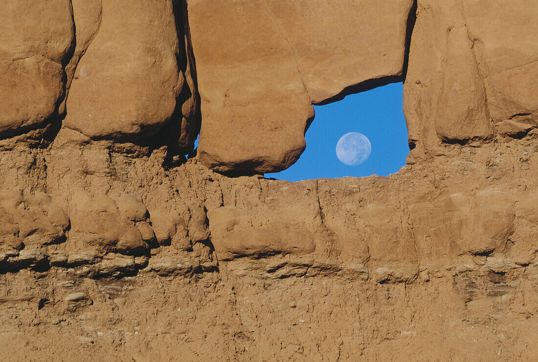 Rock hoodoos with blue sky and moon. Goblin Valley State Park. Utah, USA