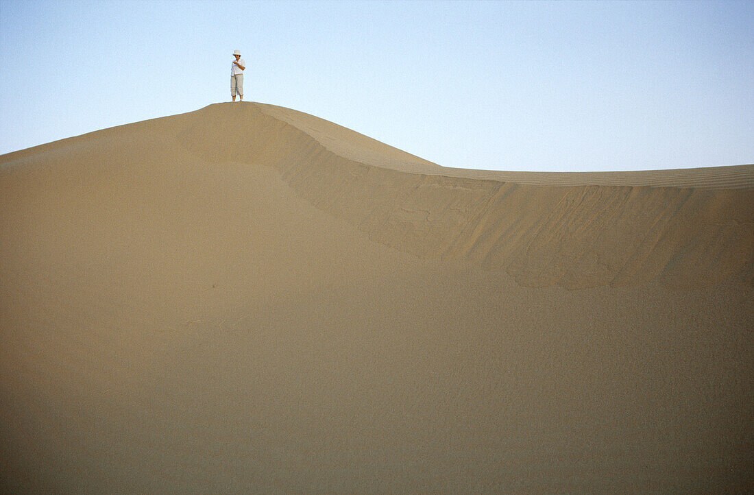 Adult, Adults, Africa, Alone, Arid, Aridity, Barren, Color, Colour, Contemporary, Daytime, Desert, Deserts, Desolate, Desolation, Dry, Dune, Dunes, Exterior, Far away, Full-body, Full-length, Heat, Horizontal, Human, Immense, Immensity, Morocco, North Afr