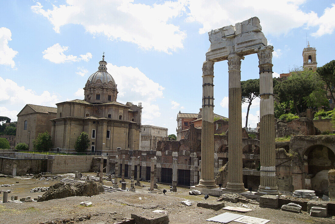 Corinthian columns on Julius Caesars forum with Chiesa dei Santi Luca e Martina (church) at background. Via dei Fori Imperiali. Rome. Italy