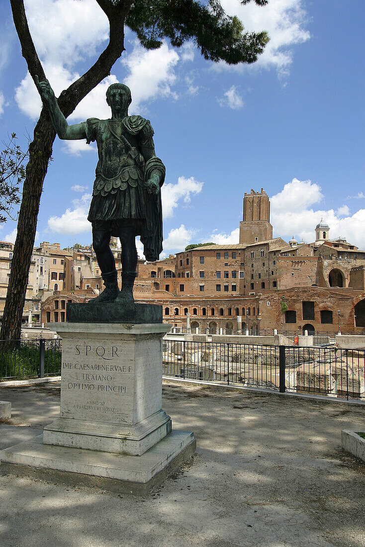 Statue of Trajan on Via dei Fori Imperiali. Trajans forum at background. Rome. Italy