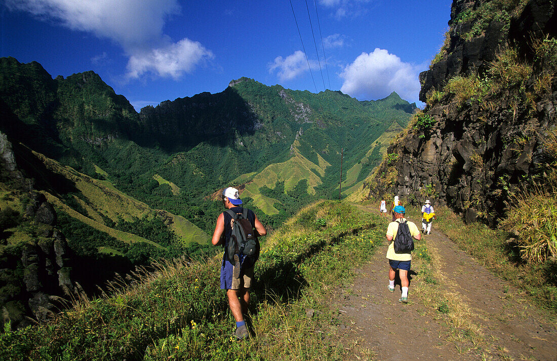 People hiking through the wild interior of the island of Fatu Iva, French Polynesia