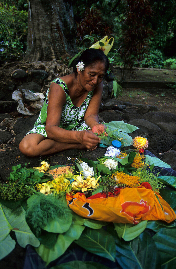 Eine marquesische Frau bindet Blumensträusse im Dorf Omoa auf der Insel Nuku Hiva, Französisch Polynesien