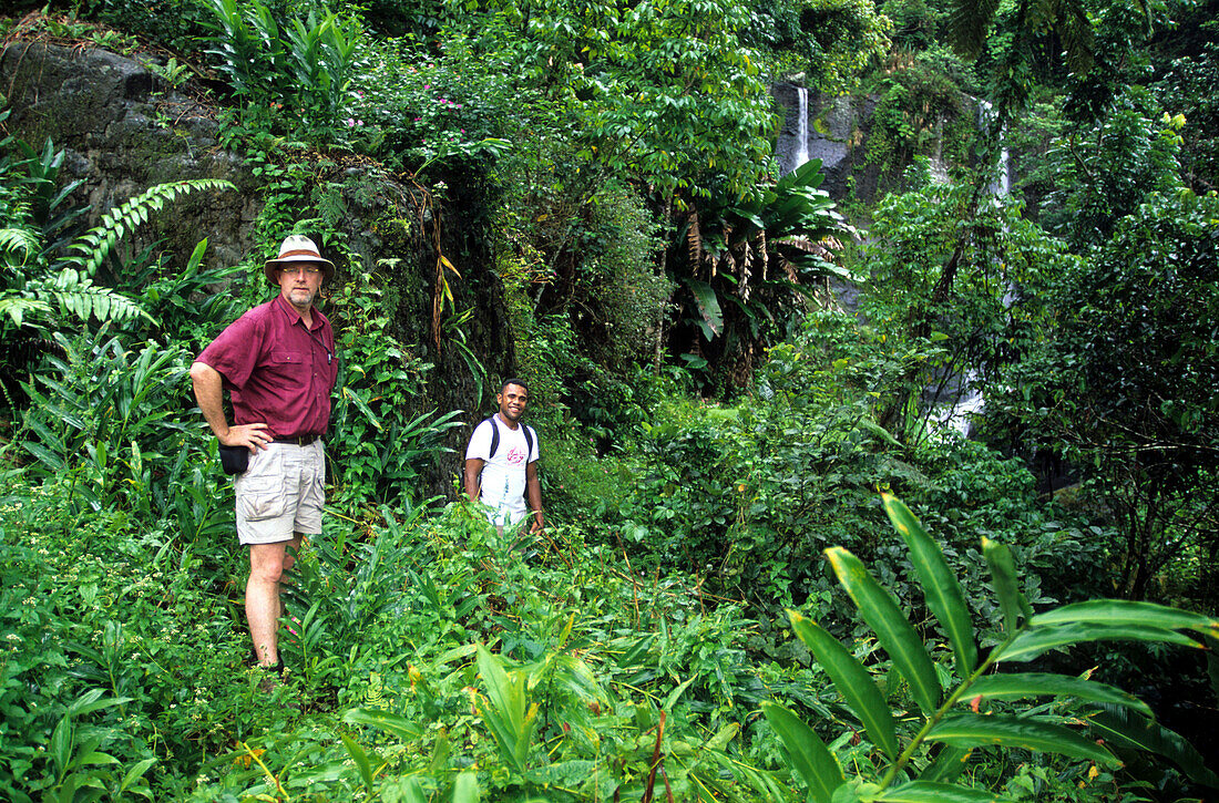 Hikers standing at hidden waterfall in the interior of Viti Levu Island, Fiji Islands