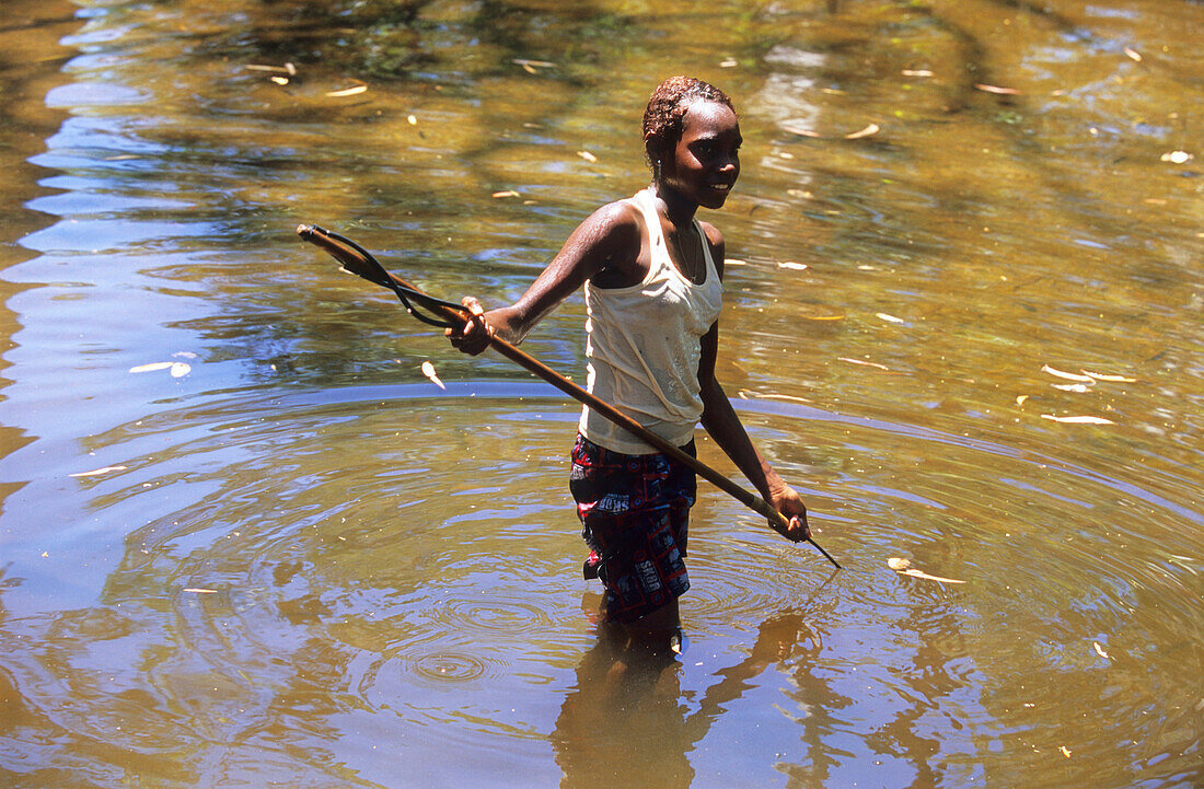 Young Aborigional girl spear fishing in the Coen River, Queensland, Australia