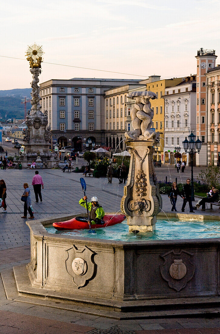 Man kayaking in a fountain at Hauptplatz, Linz, Upper Austria, Austria