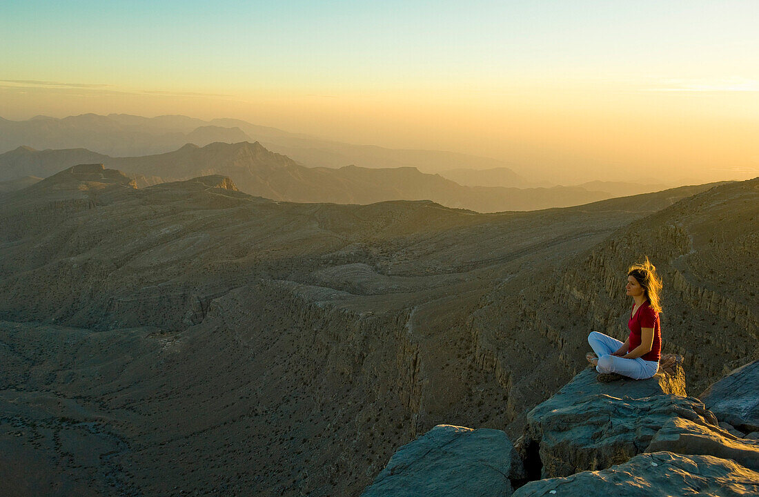 Frau geniesst den Sonnenuntergang am Sayh Plateau, Berglandschaft, Hajjar Gebirge, Kashab, Khasab, Musandam, Oman