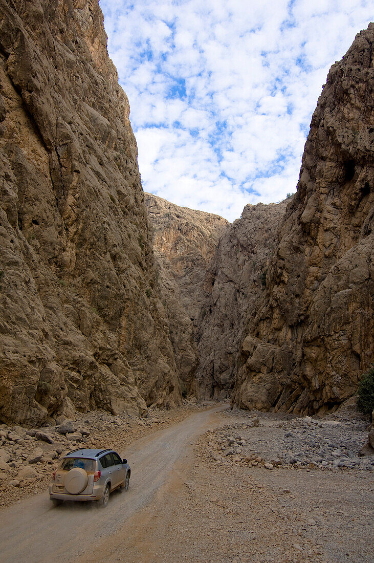 4x4 Jeep fährt durch eine Schlucht, Schottepiste, Berglandschaft, Hajjar Gebirge, Musandam, Oman