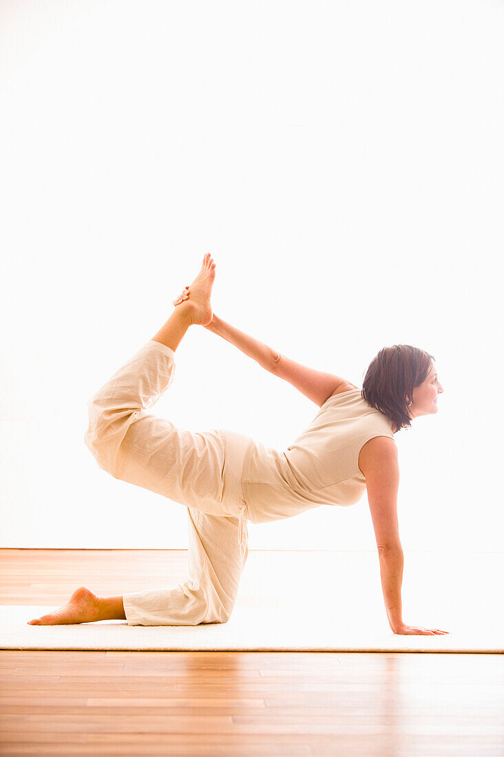 Frau mittleren Alters macht Yoga (Katze), Yogastudio in Linz, Österreich