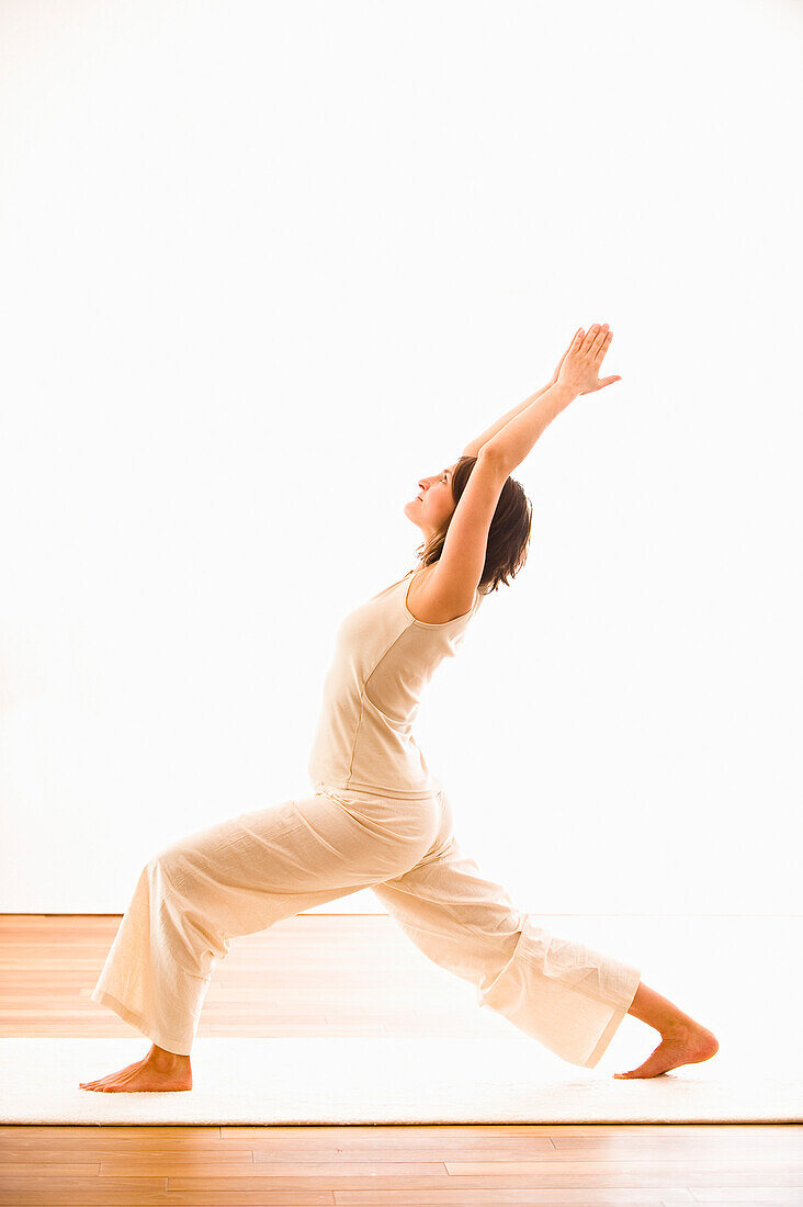 Frau mittleren Alters macht Yoga (Halbmond), Yogastudio in Linz, Österreich