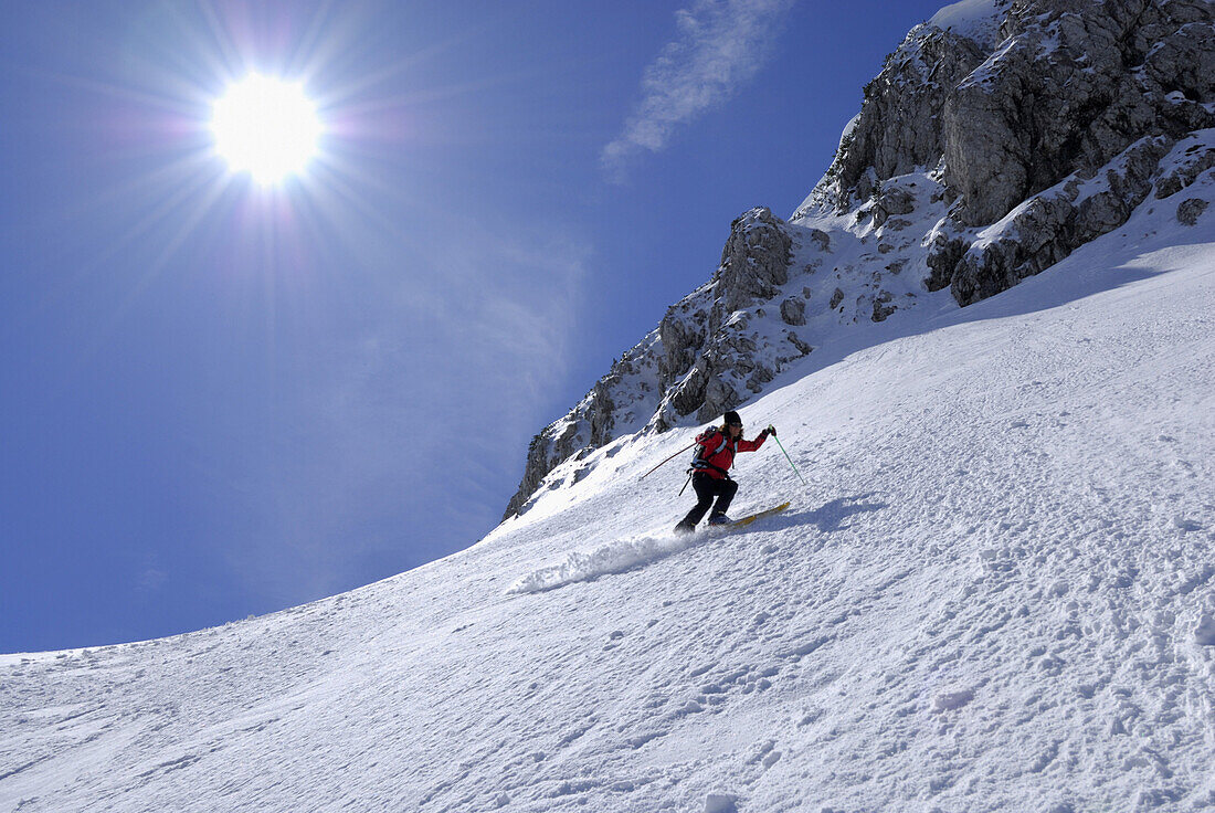 Female skier downhill skiing, Pyramidenspitze, Eggersgrinn, Zahmer Kaiser, Kaiser range, Tyrol, Austria