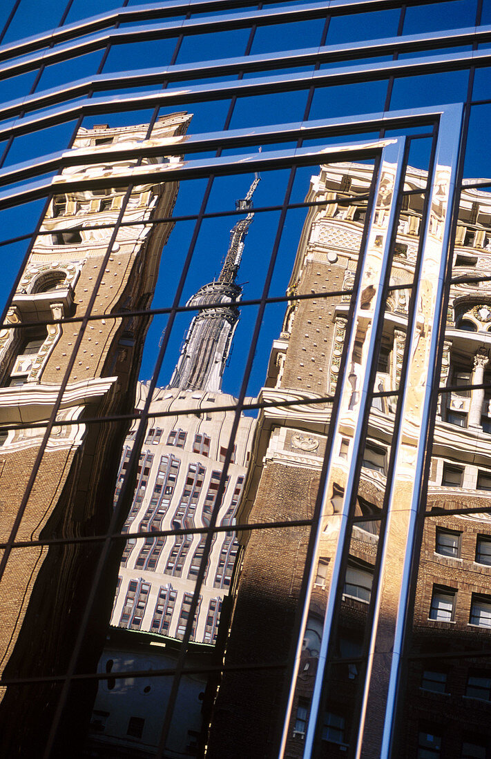 Empire State building reflecting on glass building, New York City. USA