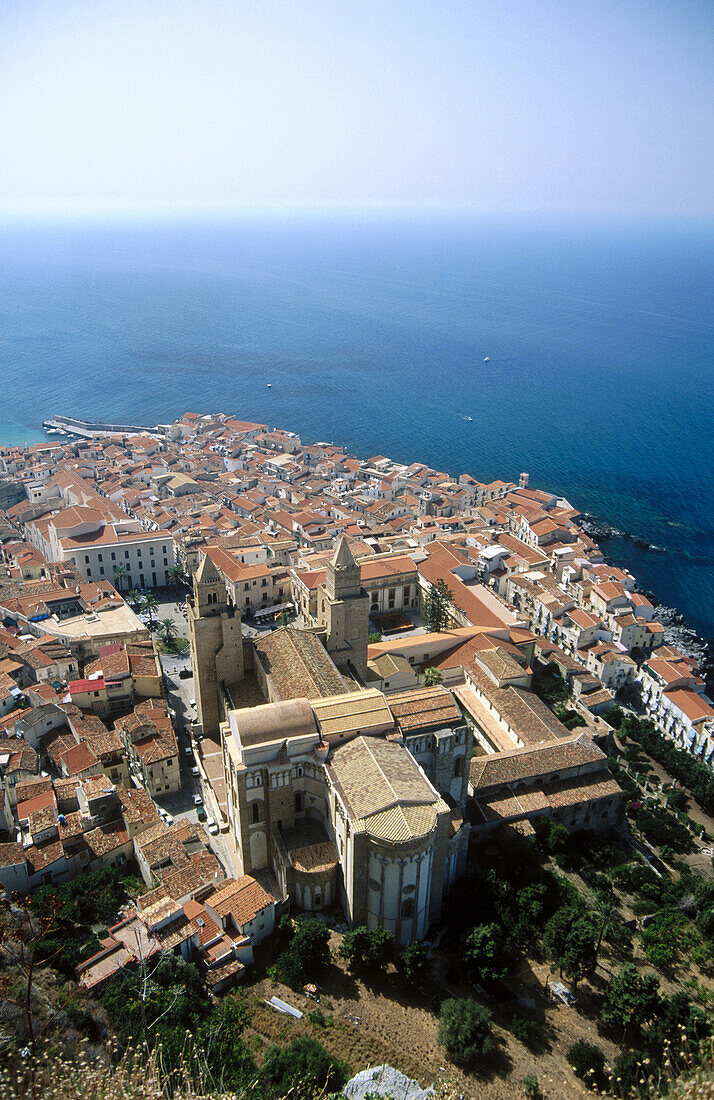 Medieval old town of Cefalù with its Norman cathedral begun in AD 1131 by the Norman king Roger II seen from the Rocca, fishing port in background. Cefalù. Sicily, Italy