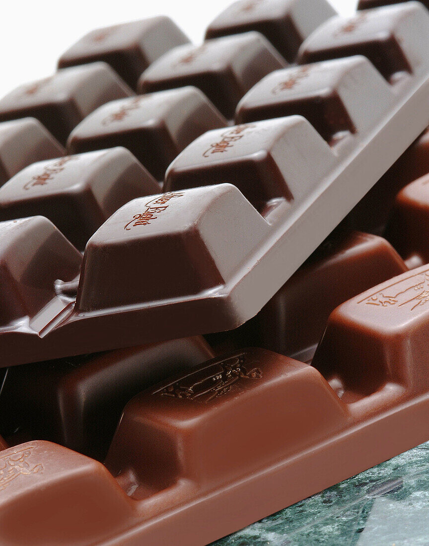 Two chocolate bars unwraped on green marble