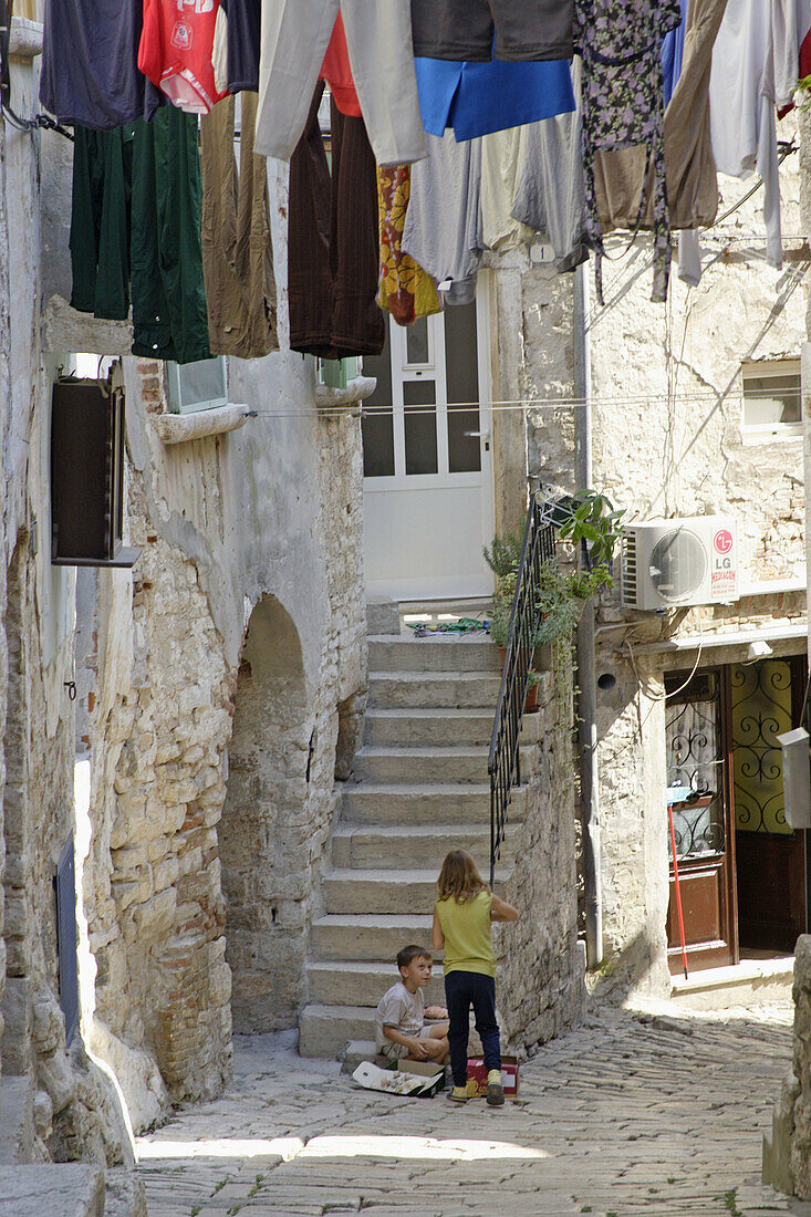 Street scene in the Old Town boy and girl playing. Rovinj. Istria. Croatia.